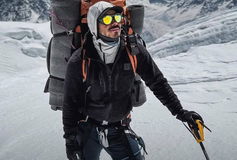Climber with gear in snowy Everest region during heli tour.