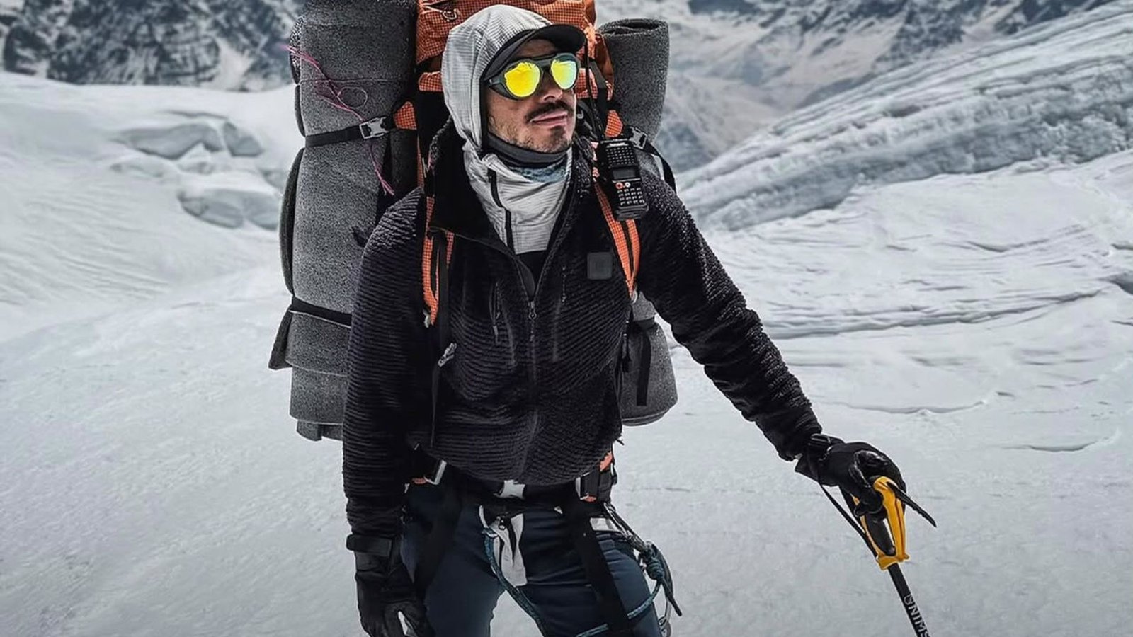 Climber with gear in snowy Everest region during heli tour.